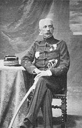 A portrait of General Lyautey in military uniform, seated at a small table