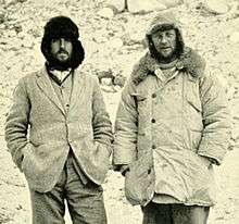 Monochrome photo of two men looking like hikers on a cold day