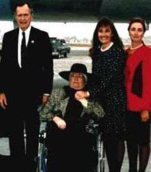 This picture shows, from left to right, President George Bush, Doris, Debra and Patti Tate. All but Doris Tate are standing in a row facing the camera. Doris Tate, who was ill with brain cancer, is in a wheelchair; Debra stands beside her, holding her hand.