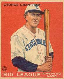 A baseball card of a man holding a bat upright and leaning on his shoulder in a white baseball uniform with "Cincinnati" written on the chest.