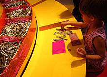 A young girl draws with Crayola crayons at the Crayola Experience