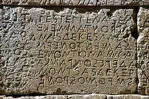 Stone wall with inscription in Greek letters.