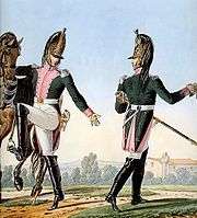 Print of two troopers of the 16th Dragoon Regiment wearing green coat with pink facings and white breeches with black riding boots.
