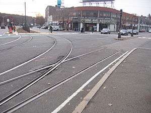 A photo of taxpayer buildings in Boston, with streetcar tracks in the foreground.