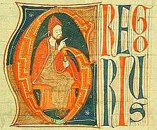 A bearded man in red robe confers benediction from a throne