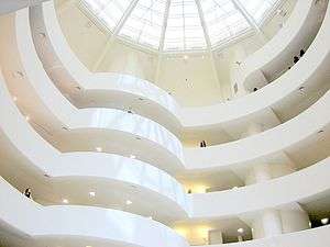The plain white interior balconies spiraling around a rotunda under a huge skylight.
