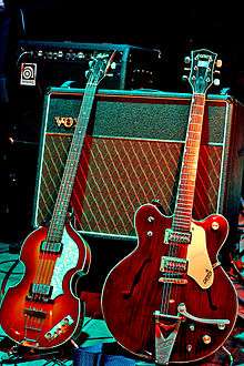 Two electric guitars displayed with an amplifier.
