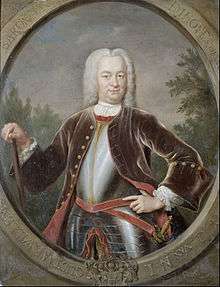 A portrait of Governor-General van Imhoff in a large white wig and black suitcoat over plate armour. He is carrying a cane in his left hand and has a sword sheathed on his right side.