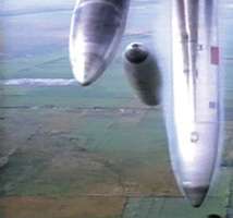 An overhead view of a plane flying over farmers' fields