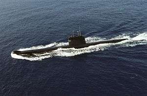 Aerial photograph of a submarine travelling on the surface of the water