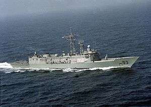 Aerial view of a frigate travelling at speed.