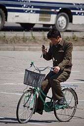 North Korean man riding a bike in Hamhung while using a cellphone.