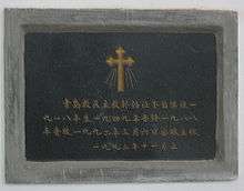 A dark granite tombstone with Chinese writing
