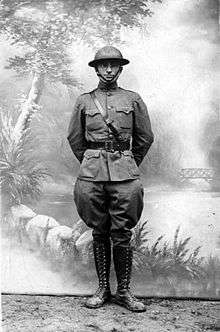 Truman in military uniform with shoulder and waist belt with helmet