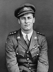 Half length portrait of man in military uniform with peaked cap and pilot's wings on left breast pocket