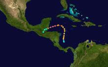 The path of a tropical cyclone, as represented by colored dots, denoting the storm's intensity and position at six hour intervals. Starting slightly right of center, the track moves up, before turning left and then to the bottom-left corner of the map.