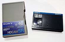 A black digital cassette tape, with its gray case on the left reading "HDCAM SR".