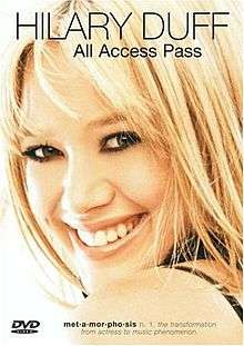 The face of a young, smiling blonde girl with brown eyes. At the top of her image, "Hilary Duff" is written in black capital letters with "All Access Pass" written in black below that. At the bottom of her image, "met-a-mor-pho-sis" is written in black bold font, followed by the text "n. 1. The transformation from actress to music phenomenon" in black italic font.