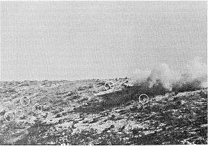 Men on a hill surrounded by explosions