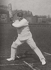 A cricketer about to hit a ball