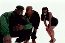 Tupac Shakur standing between actors portraying Biggie Smalls and Lil' Kim.