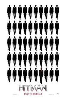 Five rows of ten indistinct figures. The forty-seventh figure is bald, wearing a suit with a white shirt and red tie.