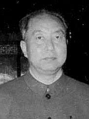 A man wearing dark clothes, starring straight at the camera
