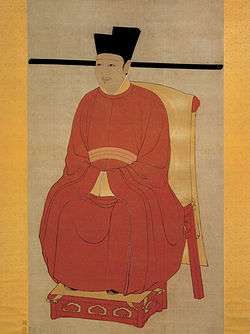 A painting of a young faced man in gold trimmed red robes, sitting on a throne made out of red wood covered in gold cloth.