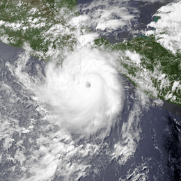 A visible satellite image of a small and compact hurricane nearing the southern coastline of Mexico.