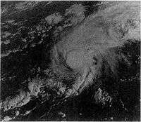 A satellite image of a hurricane. The storm has strong thunderstorm development around its small center and Bermuda is completely obscured by it