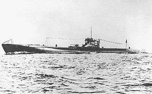 Large submarine running on the surface of the sea with a prominent deck gun and with radio mast raised