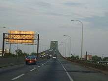 A four lane freeway ascending onto a continupus arch bridge