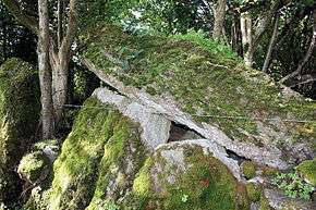 moss covered upright stones support a massive leaning stone roof slab