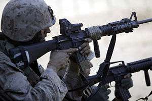 Marine aiming a loaded M16A4 rifle with EOTech optic