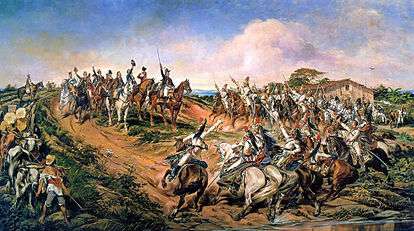 A painting depicting a group of uniformed men on horseback riding towards a smaller group of mounted men who have halted at the top of a small hill with the uniformed man at the front of the smaller group raising a sword high into the air