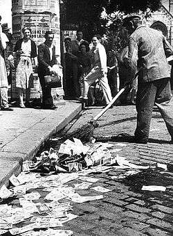 Sweeping up pengő banknotes in the street, following the 1946 introduction of the forint