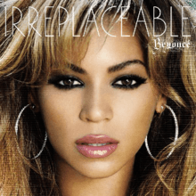 A close-up image of a brunette woman who is looking forward. She wears soft make-up, which consists of black eyeliner, pink lipstick, and earrings. On the top, the words "Beyoncé" and "Irreplaceable" are written in white letters.