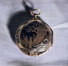 A pocket watch with an intricate Asian-themed design painted on it