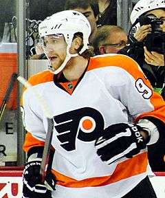 Jakub Voracek in a white away Philadelphia Flyers jersey with a white helmet on and holding his hockey stick