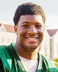 A picture of Jameis Winston while shaking someone's hand.