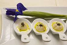 Three small dishes, with an iris above for decoration, on larger rectangular plate