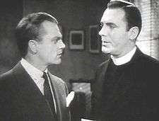 Head and shoulders shot of Cagney talking to a man in a clerical collar.
