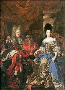 A periwigged man and a woman are seated against a sun-set milieu. The man is embracing a crown with his left hand; while the lady holds an olive branch in her right. The man wears a black armour; the lady, a silk dress.