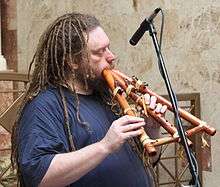 Lanier blowing into a woodwind instrument with several chambers