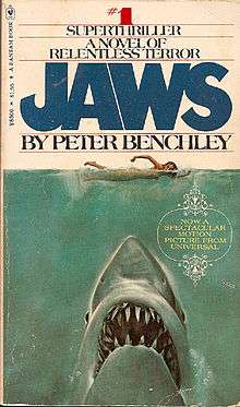 Painting of a shark head rising up on a naked swimmer. Atop the cover is "#1 Superthriller - A Novel of Relentless Horror", followed by the title and author, "Jaws by Peter Benchley".
