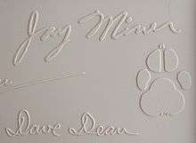 Jay Miner's signature from the top cover of a Commodore Amiga 1000 computer, along with his dog Mitchy's pawprint.