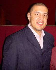 A man with short hair wearing a blue suit jacket and white shirt