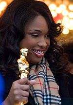 Headshot of an African-American female in her late twenties holding her Oscar statuette