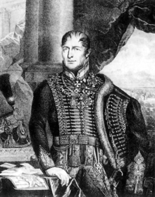 Black and white half-length portrait of General Frimont wearing a full hussar-style dress. His black strands of hair conceal his early baldness. He looks to the left of the viewer and keeps his right hand on a table and his left one on the hip, covered by the pelisse. He has multiple decorations on his chest.