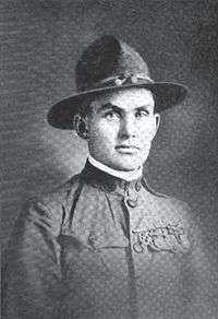 Head and shoulders of a clean-cut square-jawed young man in an army uniform, U.S. Army World War I style, with a campaign hat.